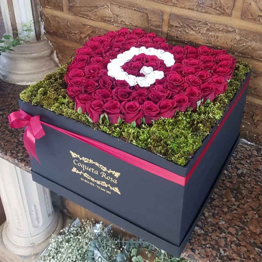 Box with a G in white roses on moss